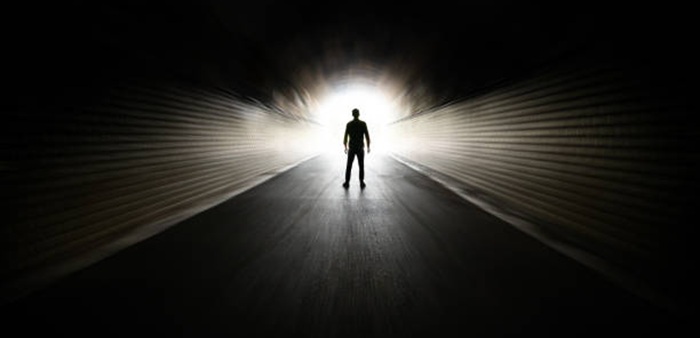 Man walking in dark tunnel